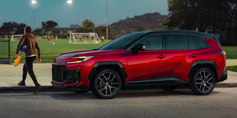 Red Toyota RAV4 Plug In Hybrid parked outside soccer field